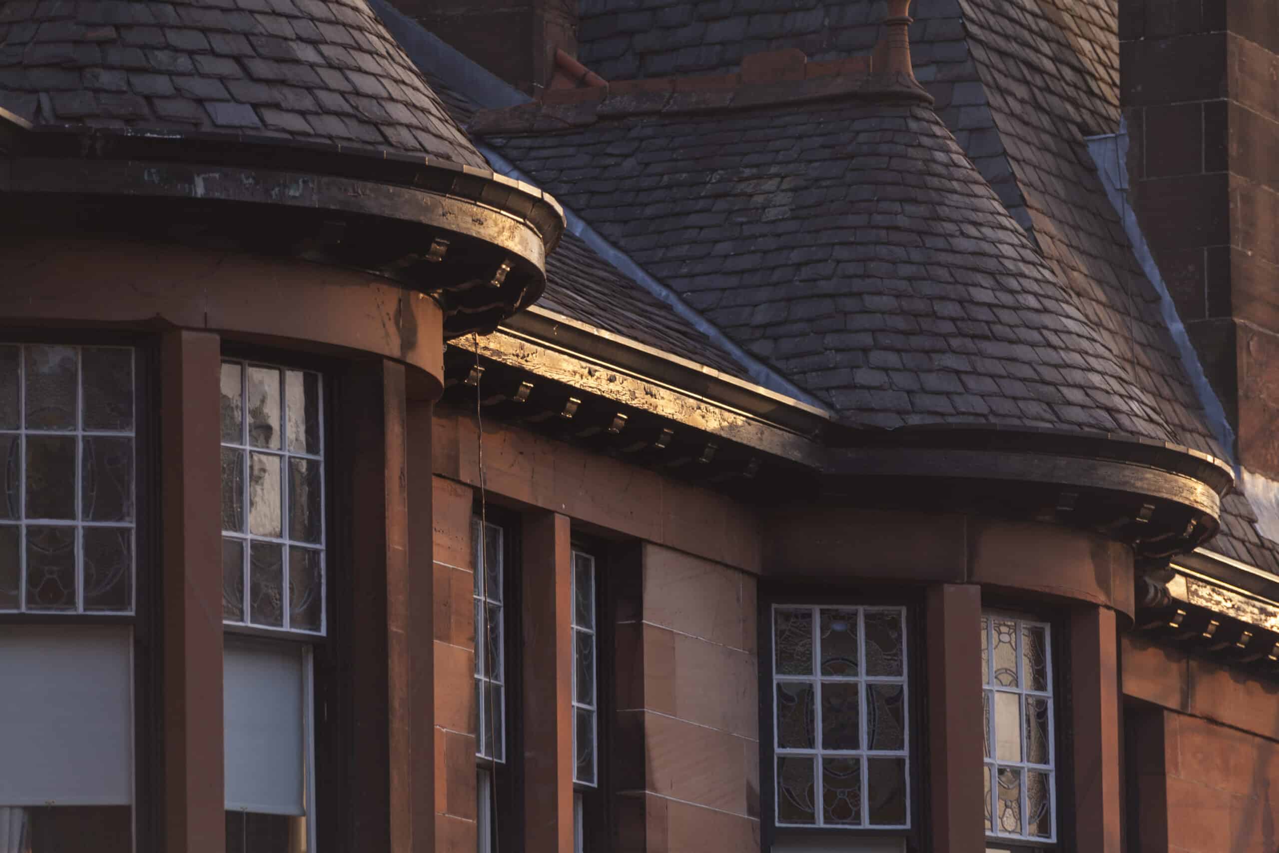 Traditional red sandstone townhouse on Dowanside Road in Glasgow West End with slate roof and stained glass windows