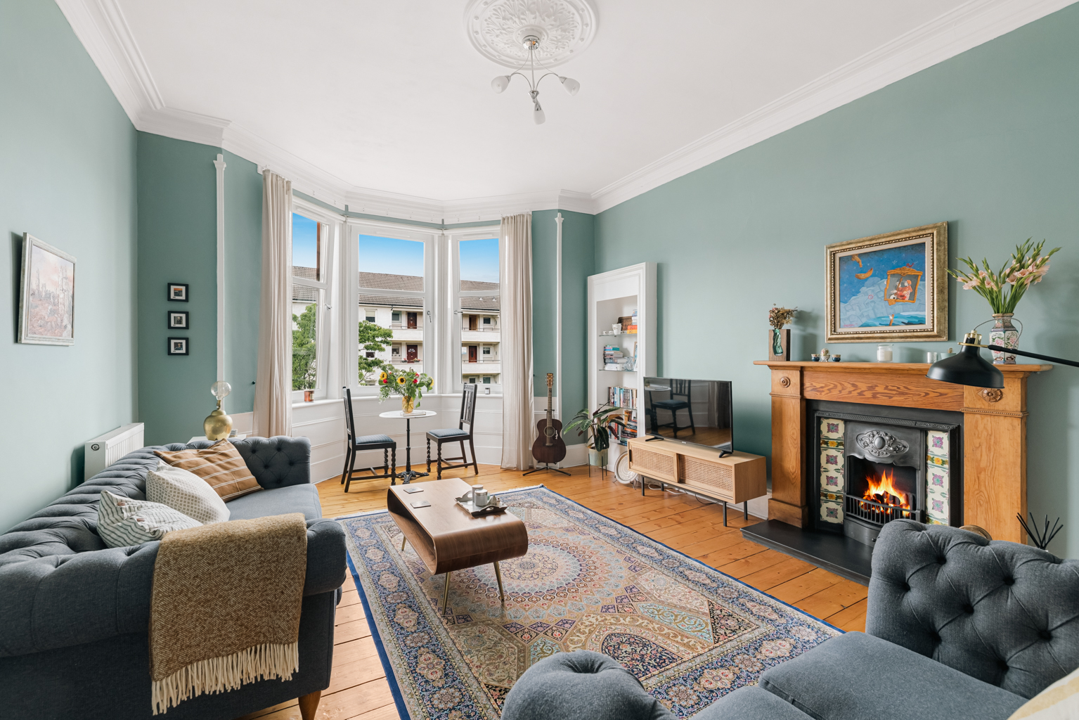 Traditionally styled Glasgow West End lounge with bay window, cornicing and original fireplace, presented for sale